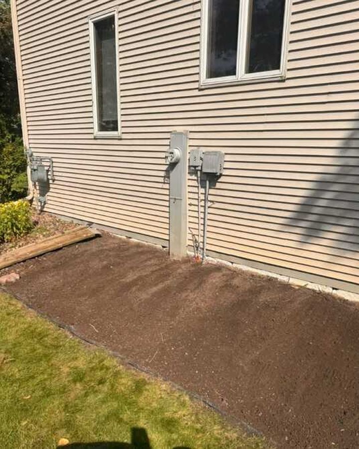 Cleared side yard with a fresh bed by the AC unit